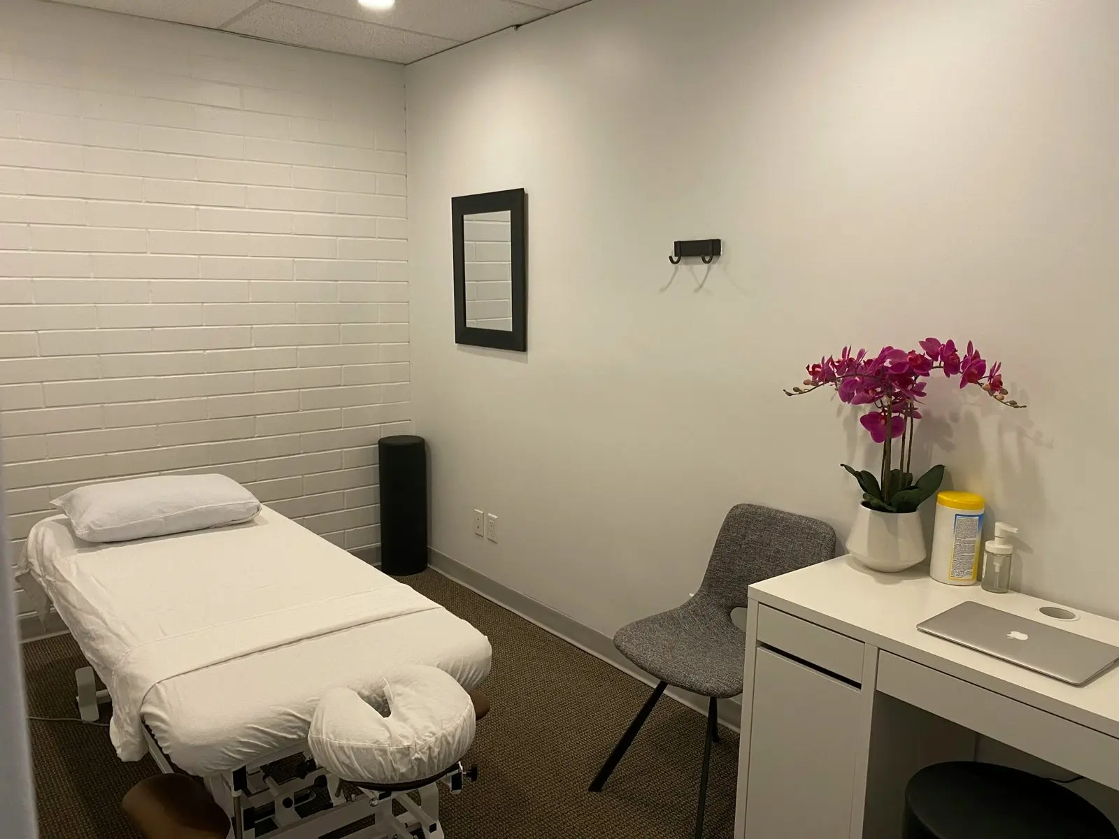 A calm, bright treatment room with a bed