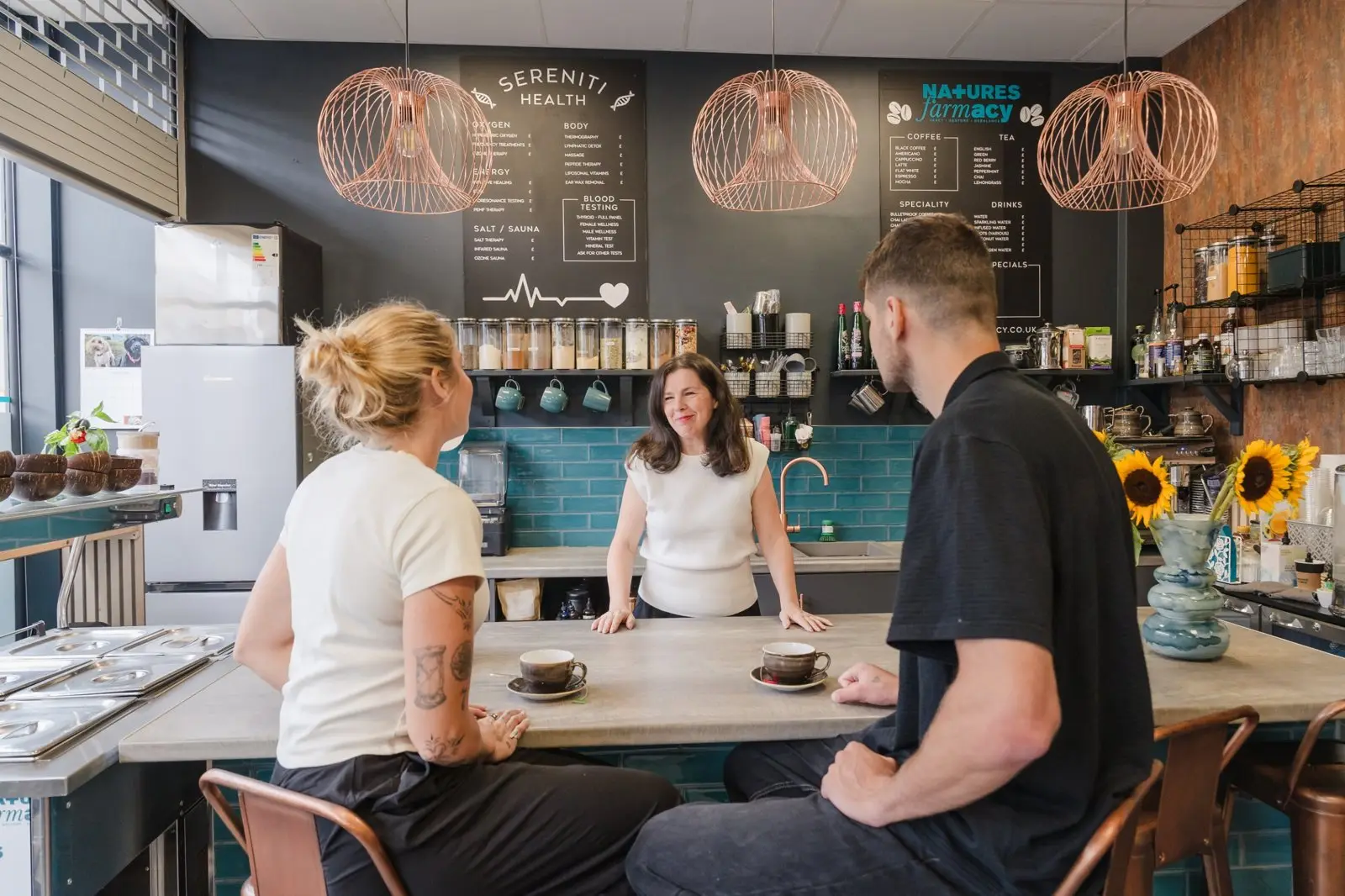 Michelle chatting with two clients over tea at the Natures Farmacy counter
